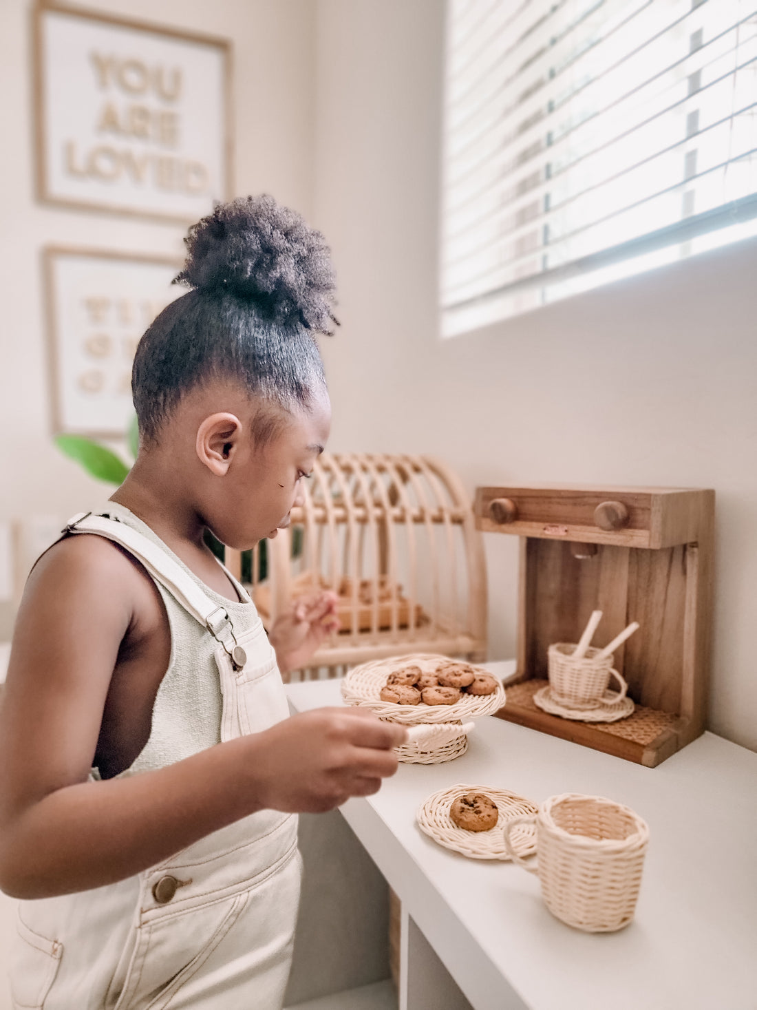 a girl playing with sustainable rattan coffee tea set and wooden coffee maker by poppie toys pretend play