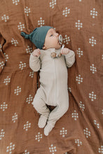 Load image into Gallery viewer, baby with pacifier wearing organic cotton oatmeal color zipper footed pajamas with knot hat by mebie baby