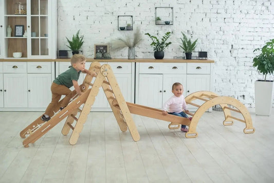 two toddlers playing on natural wood montessori pikler triangle ladder, ramp and wooden arch eco-friendly non-toxic indoor toddler playground