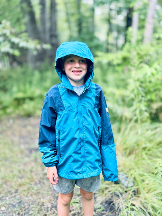 boy wearing non toxic rain jacket by reima