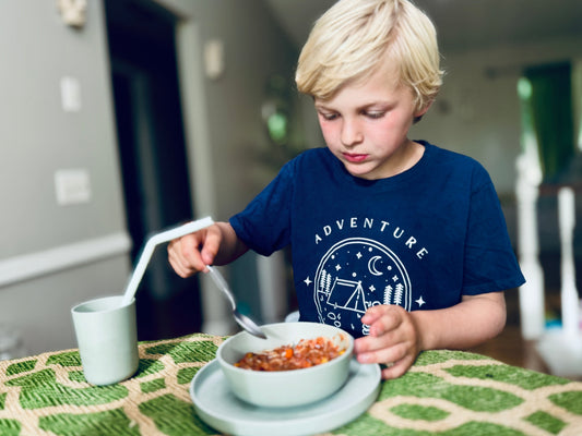 little boy eating from non toxic plant based bamboo dinnerware by eco cubs