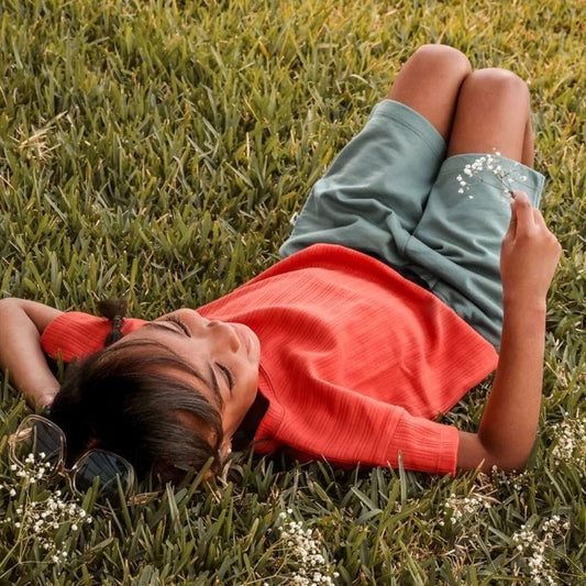 kid laying on grass summer non toxic capsule 