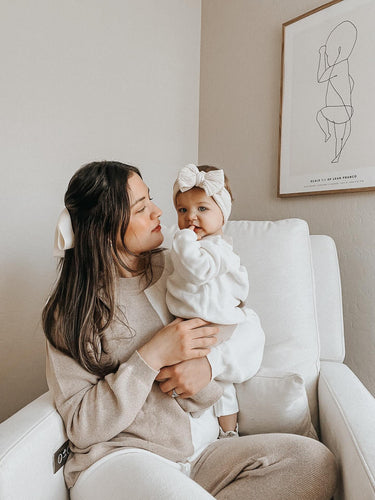 mom holding baby girl wearing organic cotton knit color block beige and white lounge set with matching baby girl outfit