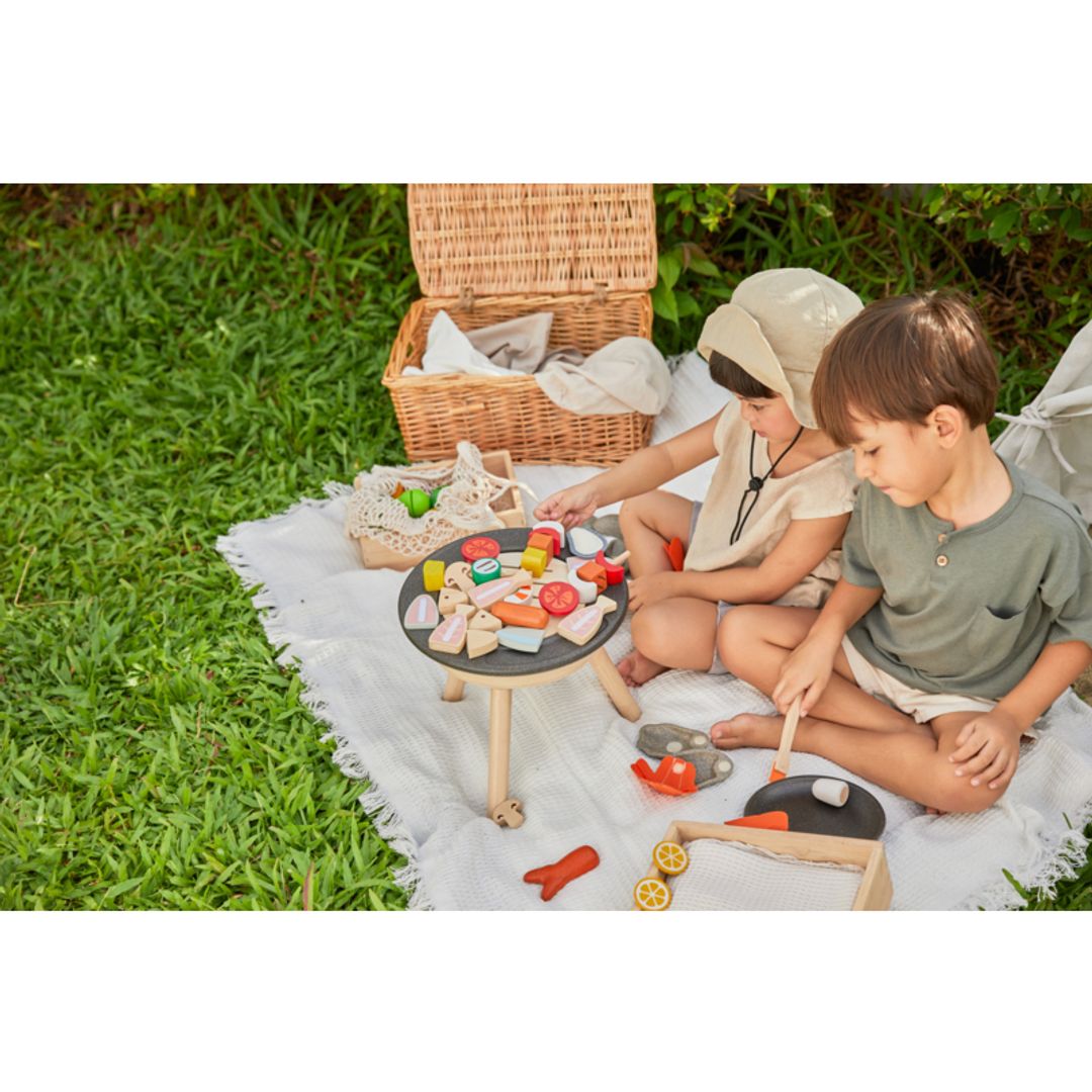 two little kids playing with eco-friendly non-toxic wooden bbq  set by plantoys 