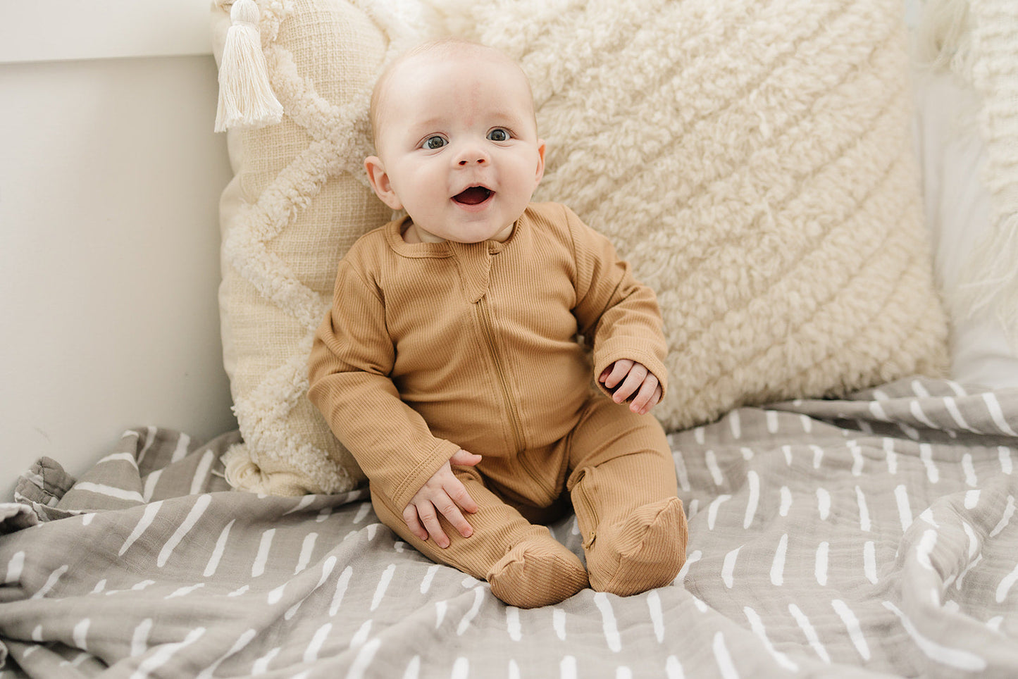 smiling baby wearing non-toxic eco-friendly organic cotton zipper pajamas in brown color by Mebie Baby