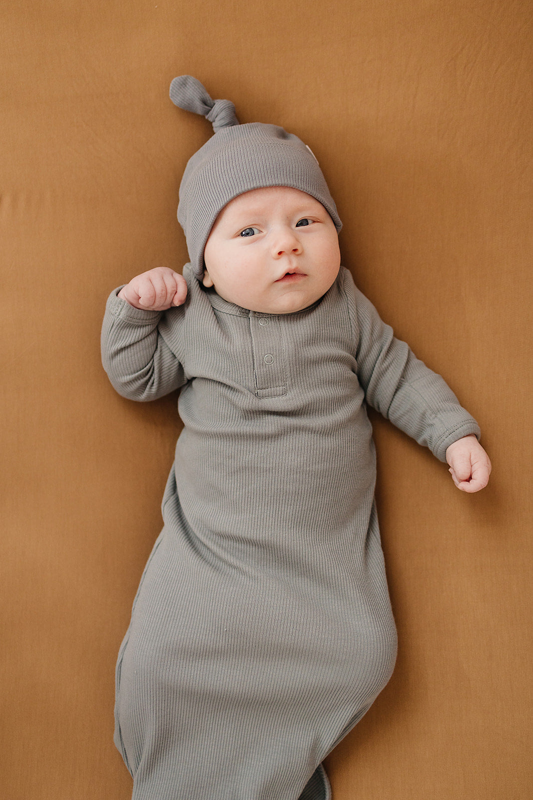 baby laying down wearing organic cotton ribbed knot hat and matching knot gown in grey color by mebie baby