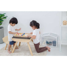 Load image into Gallery viewer, two little kids playing eco-friendly wooden shuffleboard by plantoys
