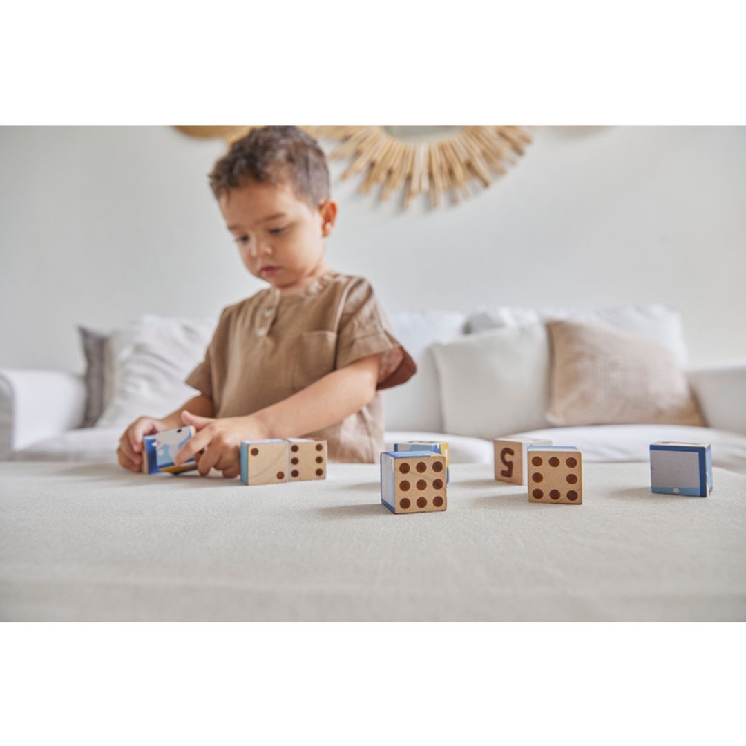 little boy playing with wooden eco-friendly non-toxic puzzle cubes by plantoys