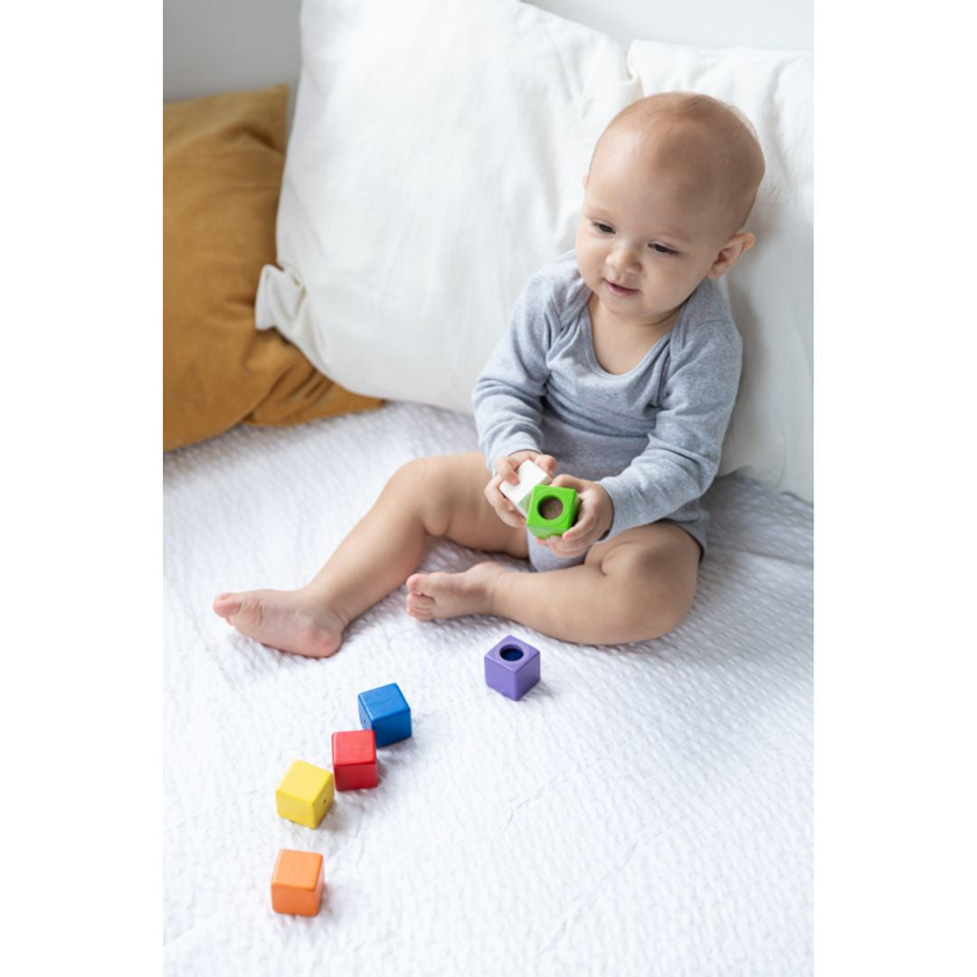baby playing with wooden non-toxic eco-friendly plantoys colorful sensory activity blocks