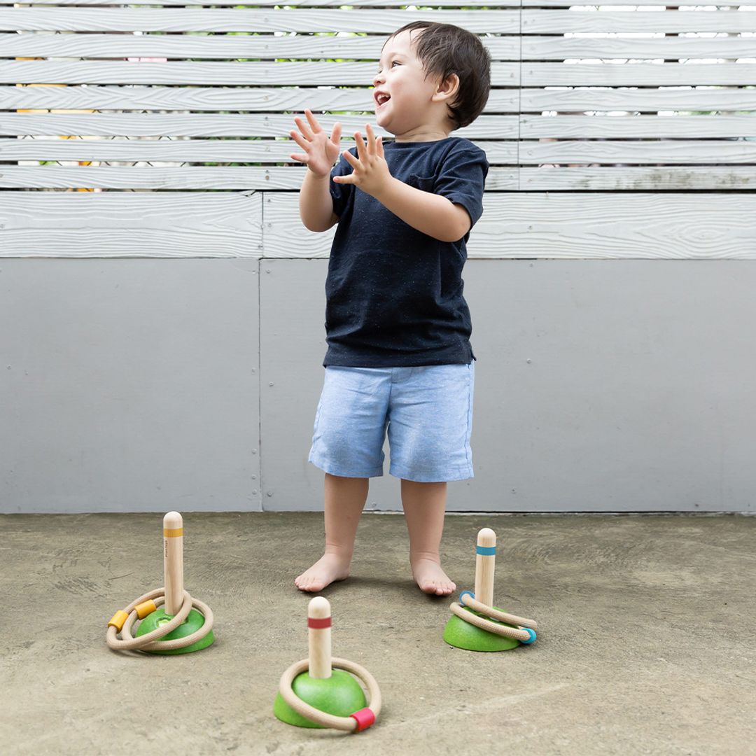 a boy playing with sustainable wooden non-toxic ring toss game