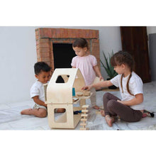 Load image into Gallery viewer, two girls and a boy playing pretend with eco-friendly non-toxic contemporary wooden doll house by plantoys
