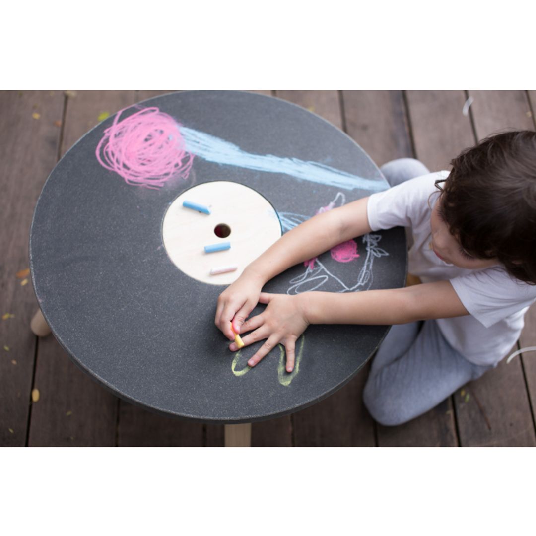 little boy drawing with chalk on kids' sustainable non-toxic chalkboard table
