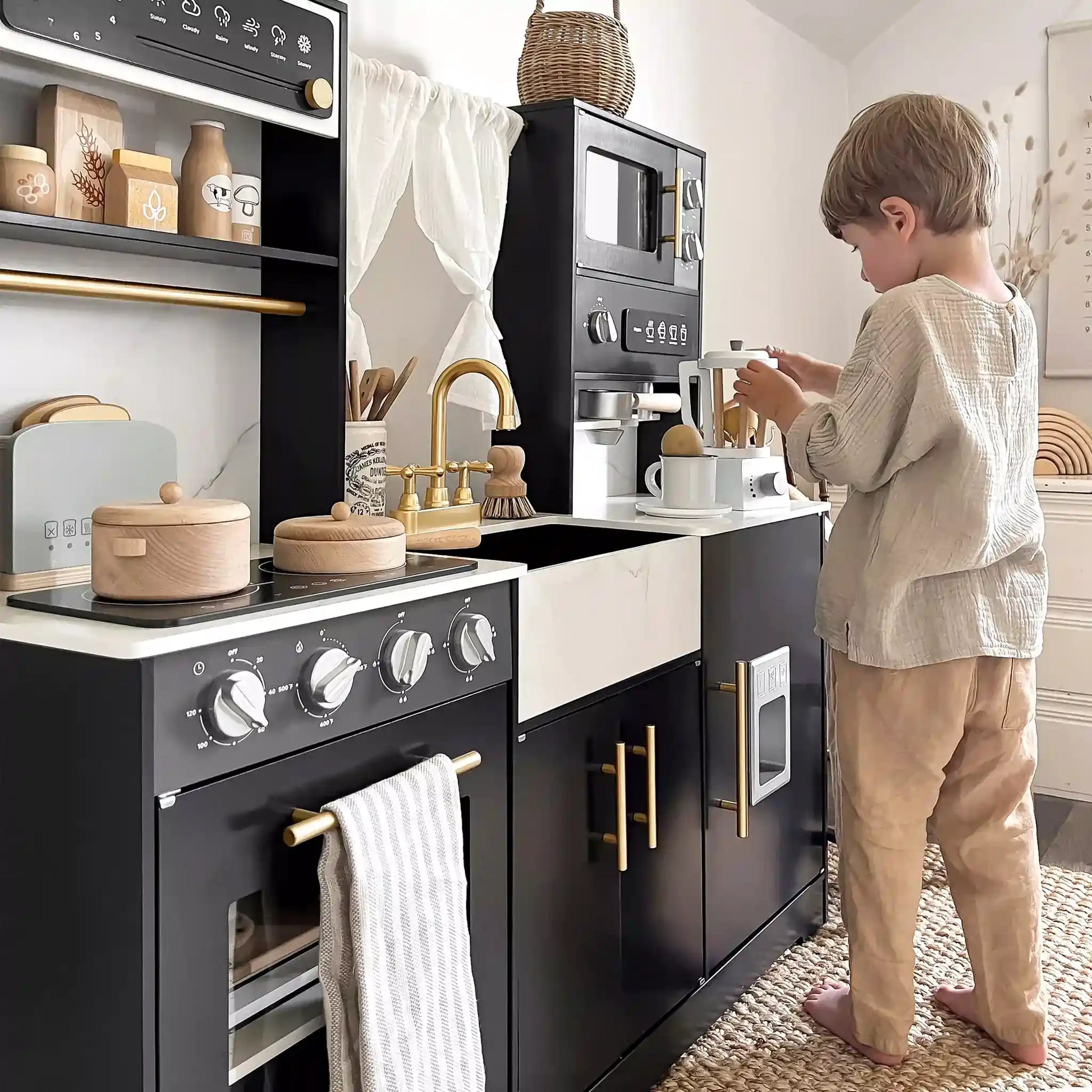 a boy playing with pretend kitchen wooden eco-friendly by tiny land