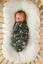 Load image into Gallery viewer, baby in bassinet in christmas nutcracker green bamboo swaddle by mebie baby
