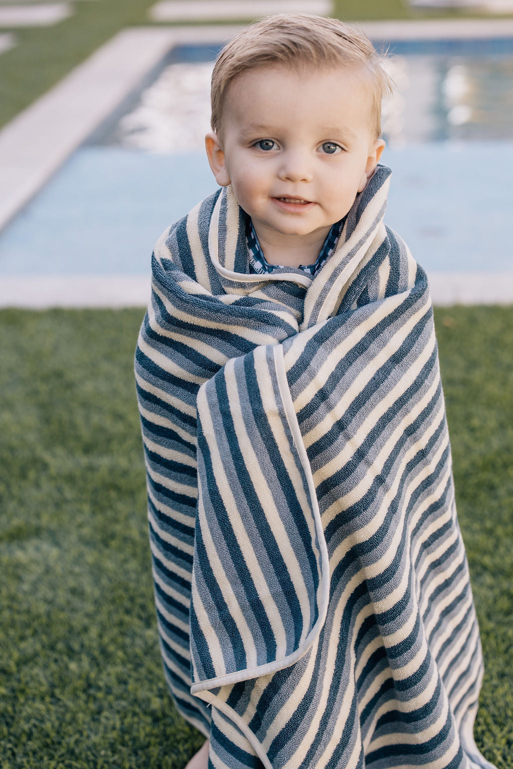 little boy wrapped in organic cotton sustainable eco-friendly non toxic blue striped hooded beach towel