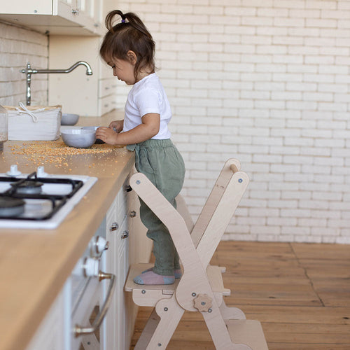 little girl helping in the kitchen on eco-friendly non-toxic wooden foldable montessori kitchen tower step stool 