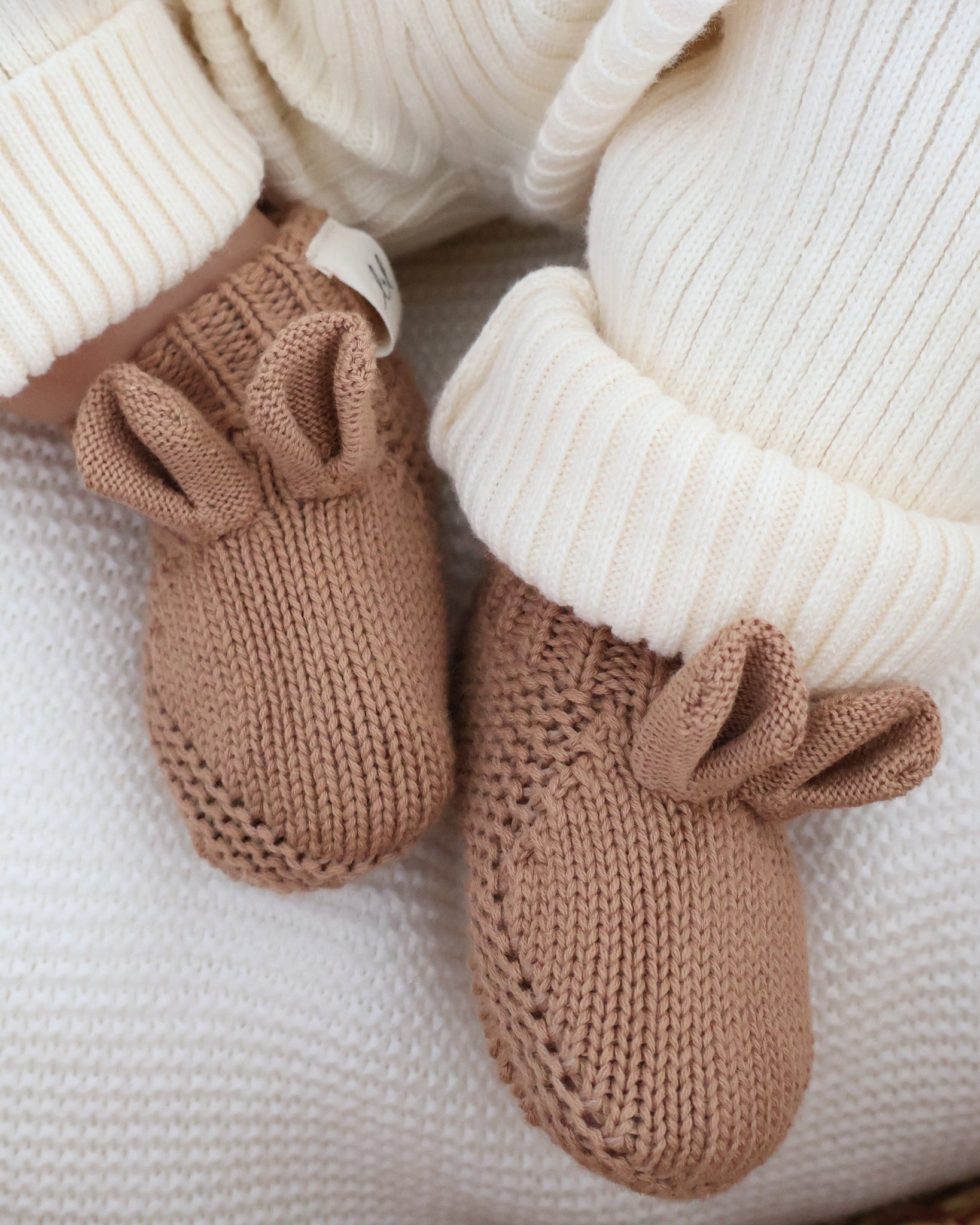 A pair of adorable organic cotton baby booties shaped like little bears from Luca + Luna.