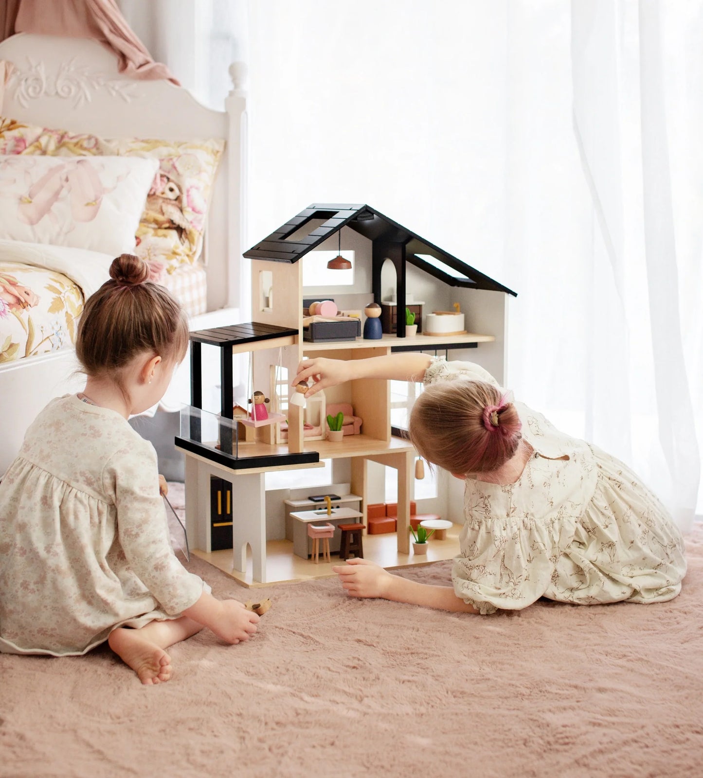 two girls playing with wooden modern dollhouse sustainable non-toxic by tiny land