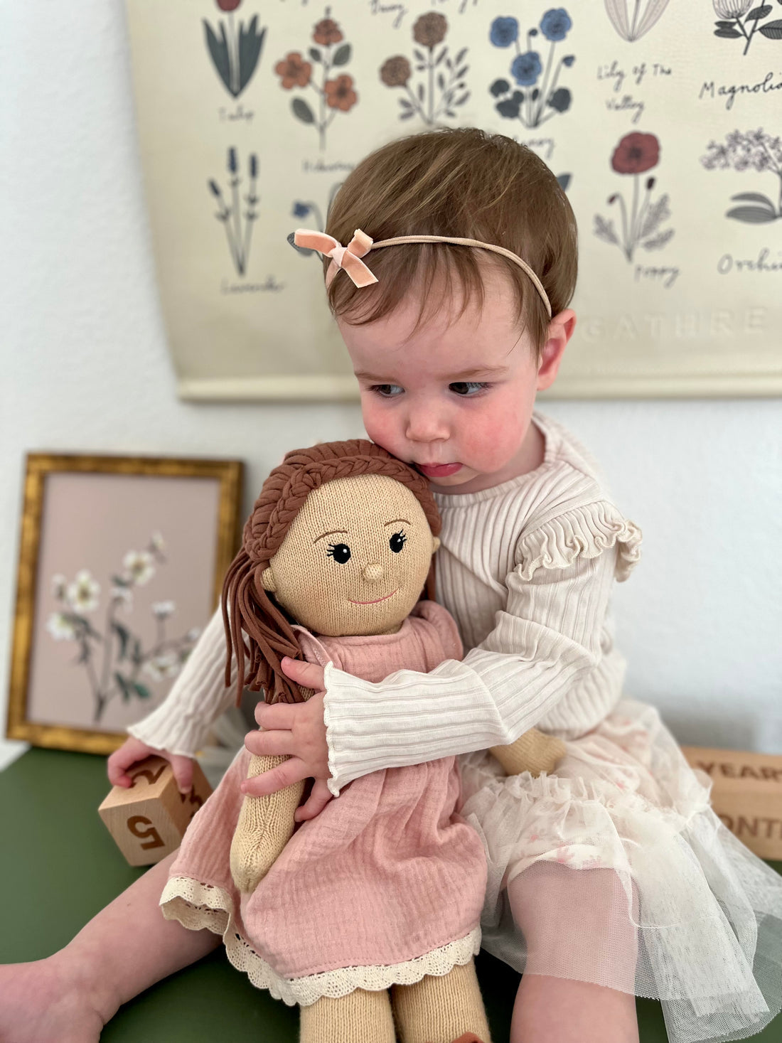 toddler girl playing wtih eco-friendly knitted doll by poppie toys 