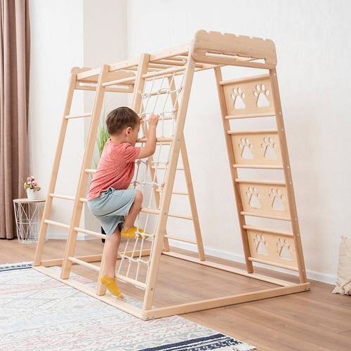 a boy climbing on eco-friendly non-toxic natural wooden indoor playground jungle gym by wood and hearts