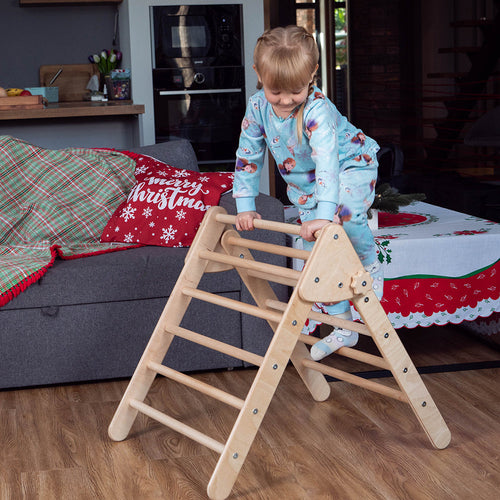 little girl climbing eco-friendly non-toxic wooden montessori pikler triangle by wood and hearts