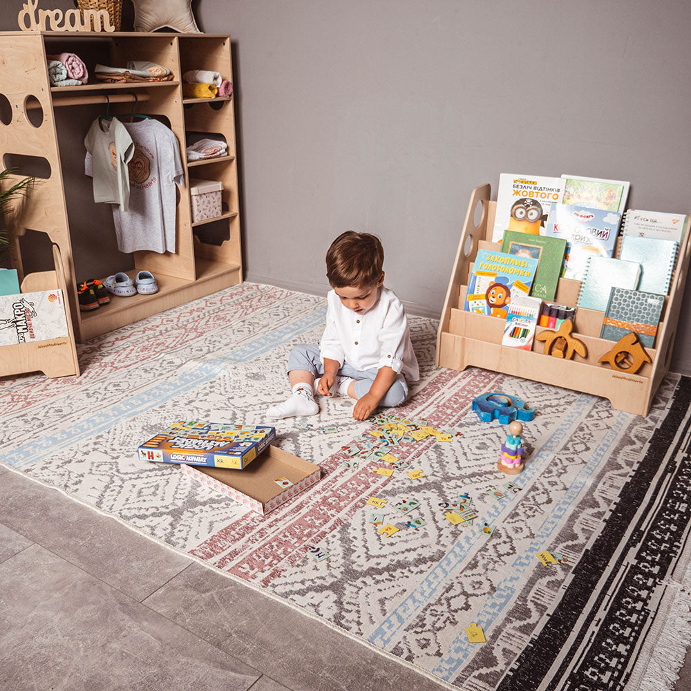 little boy playing in his room with eco-friendly wooden montessori book shelf 