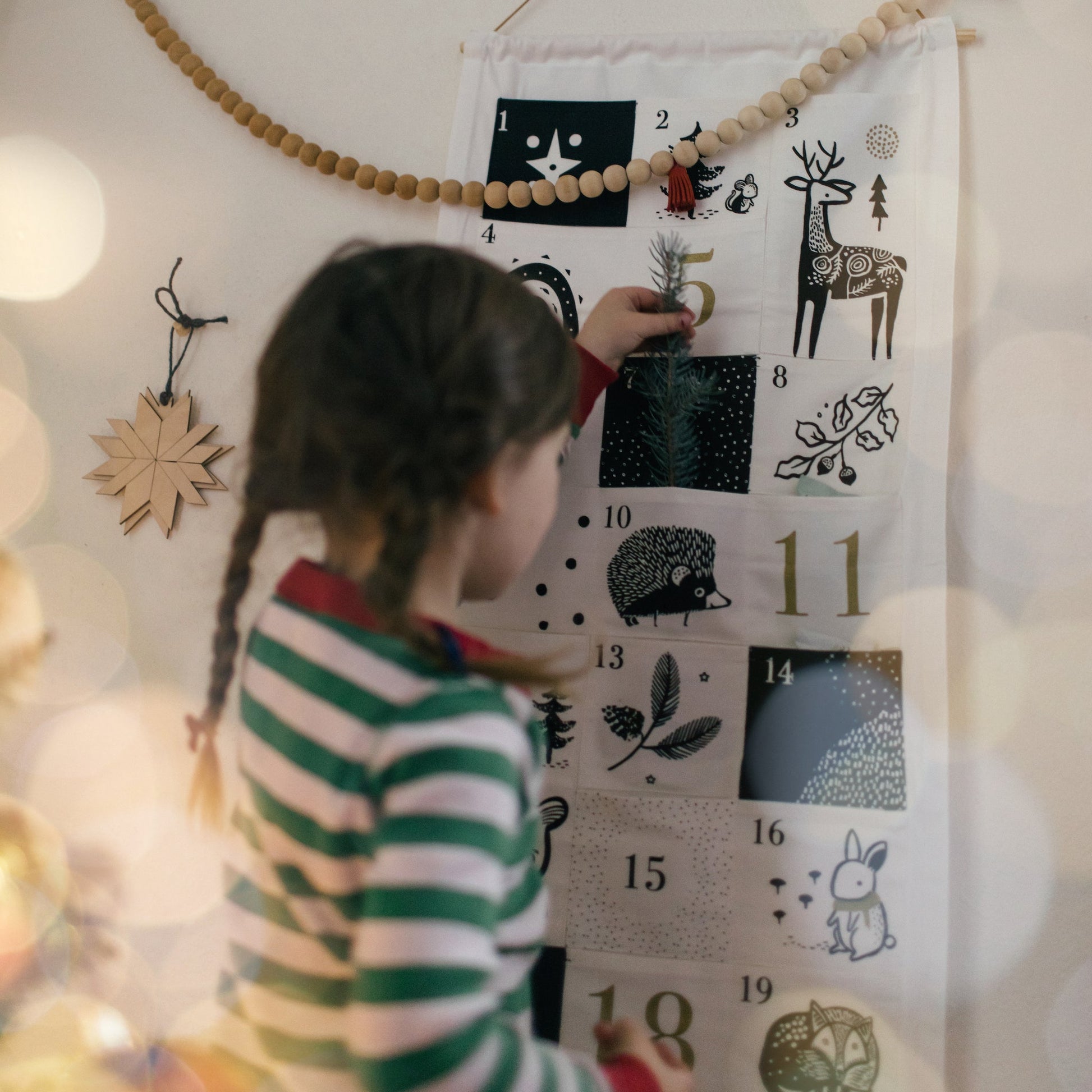 little girl checking organic cotton nature-inspired advent calendar christmas non-toxic eco-friendly by wee gallery