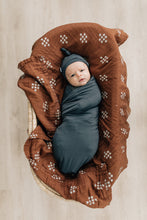 Load image into Gallery viewer, baby in bassinet wrapped in eco-friendly bamboo swaddle and wearing bamboo matching charcoal knotted hat by mebie baby
