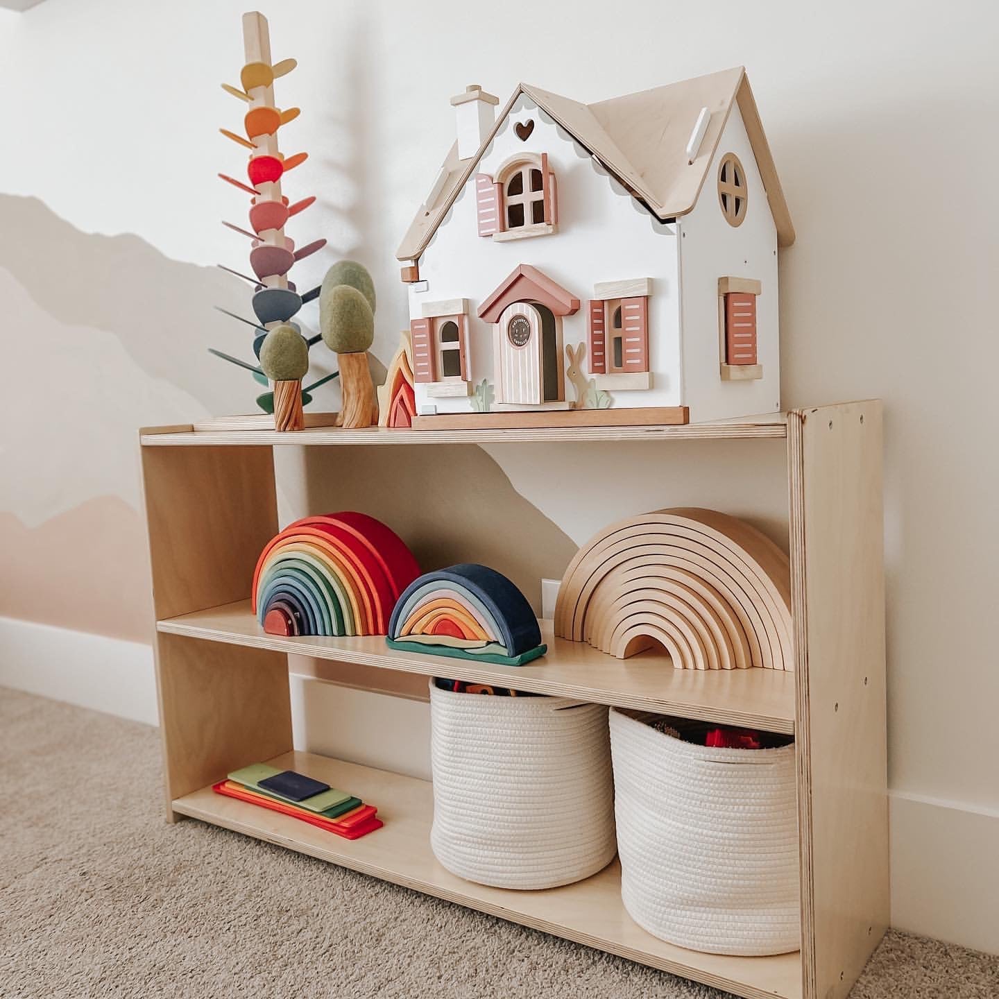 A low wooden shelf with a curated selection of Montessori toys.