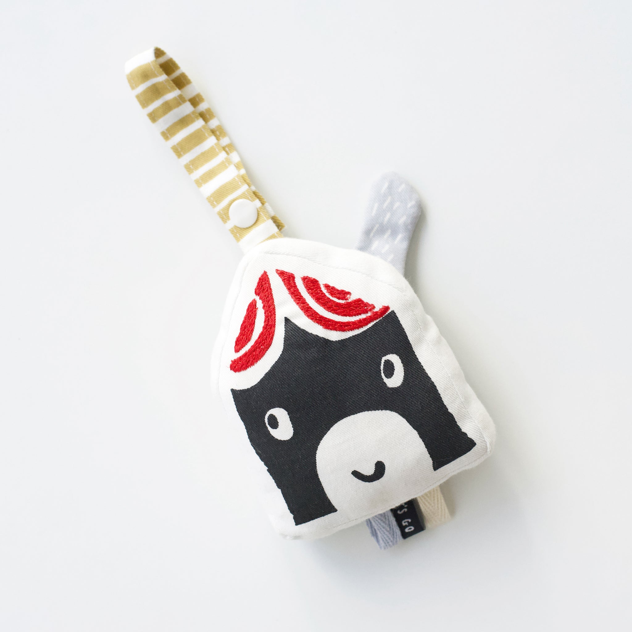A high-contrast house-shaped organic cotton hanging toy from Wee Gallery that makes a crinkle sound.