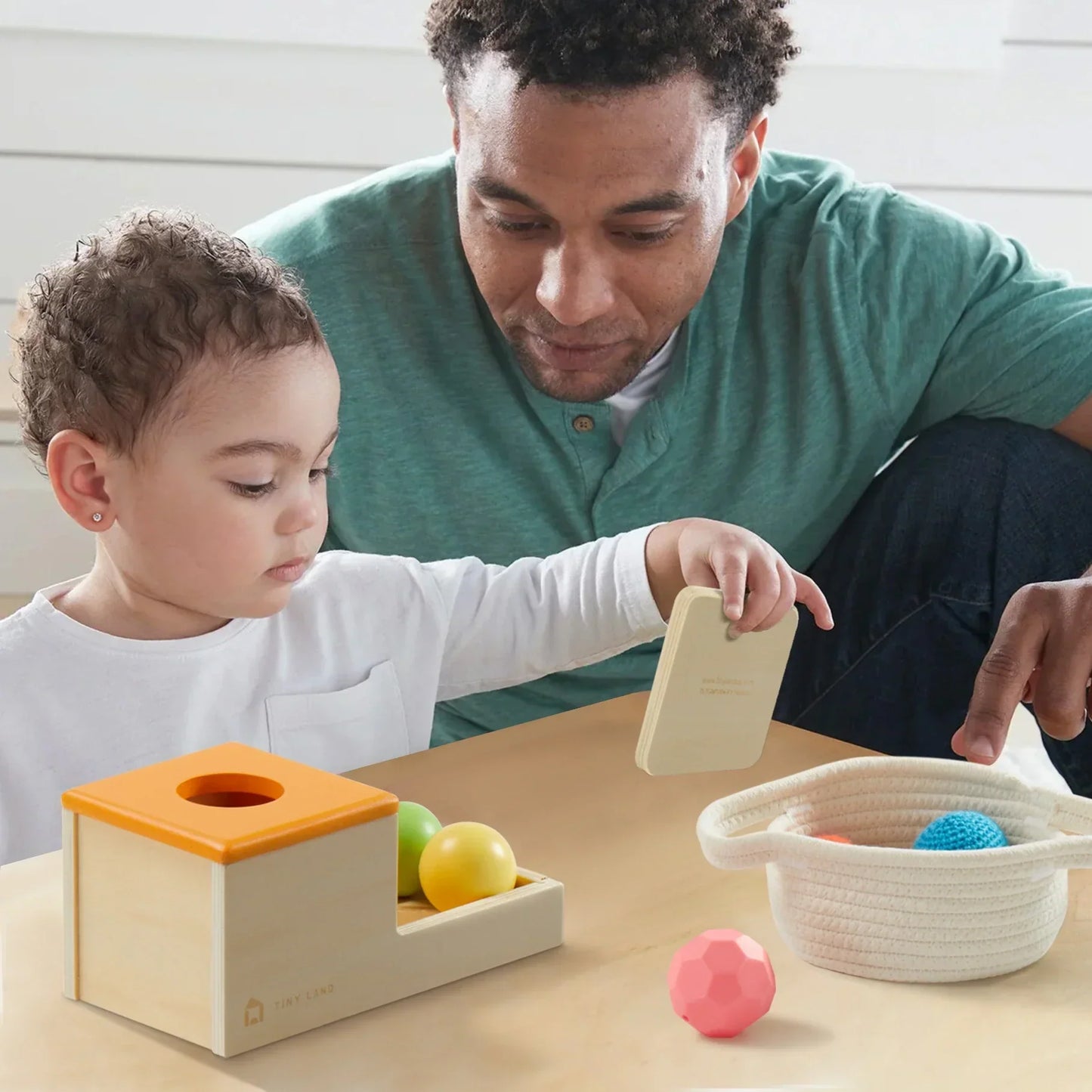 dad and toddler boy playing with object permanent box montessori by tiny land