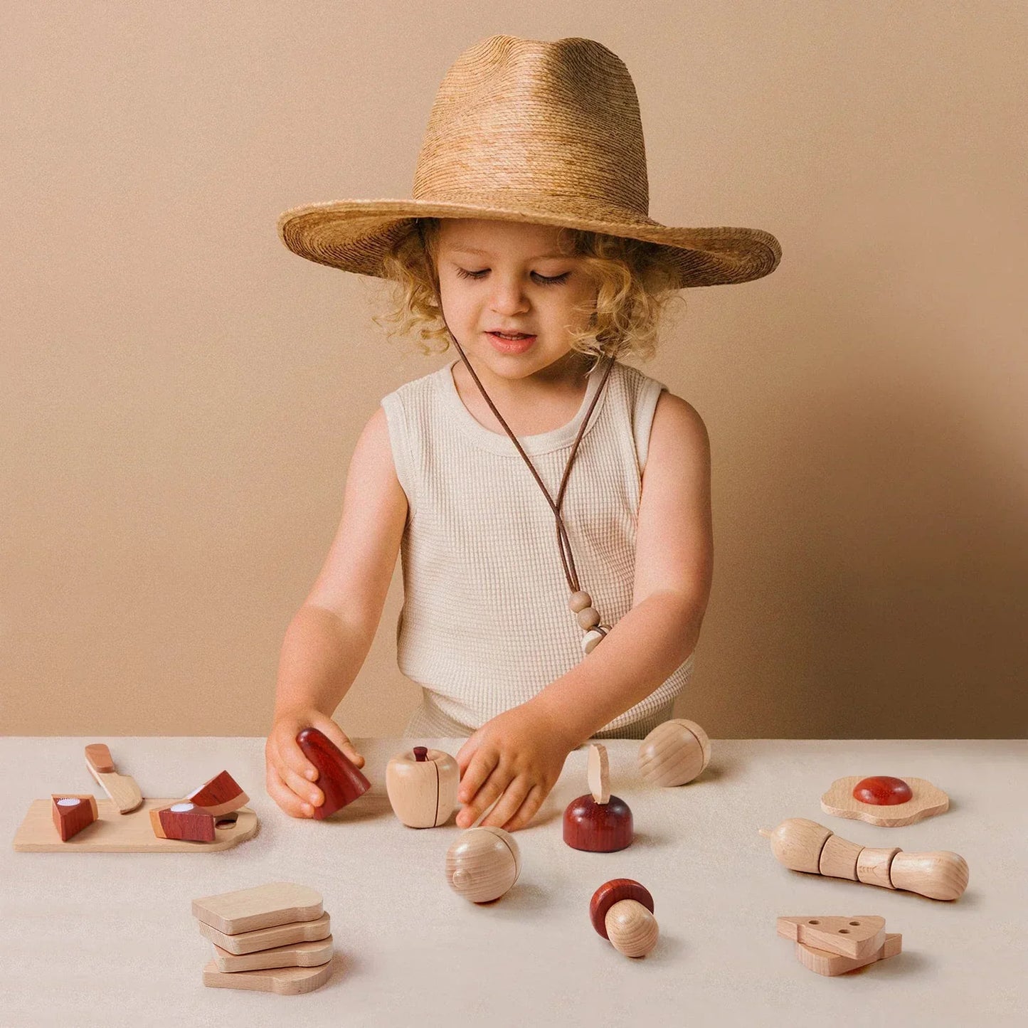 little girl playing with eco-friendly wooden play food by tiny land