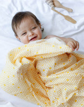 Load image into Gallery viewer, infant smiling covered with organic cotton muslin beehive swaddle blanket
